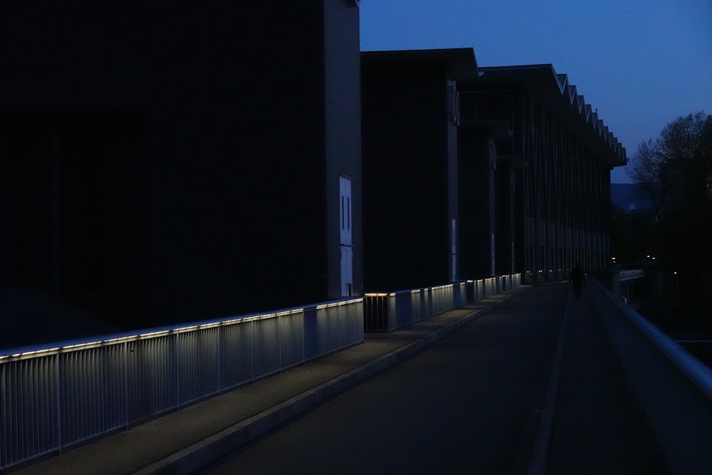 man walking on a street on side of buildings