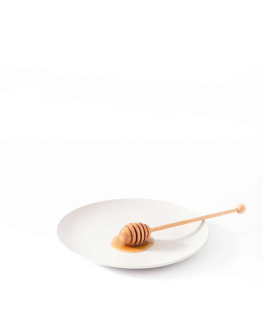cucharón de miel en plato vacío