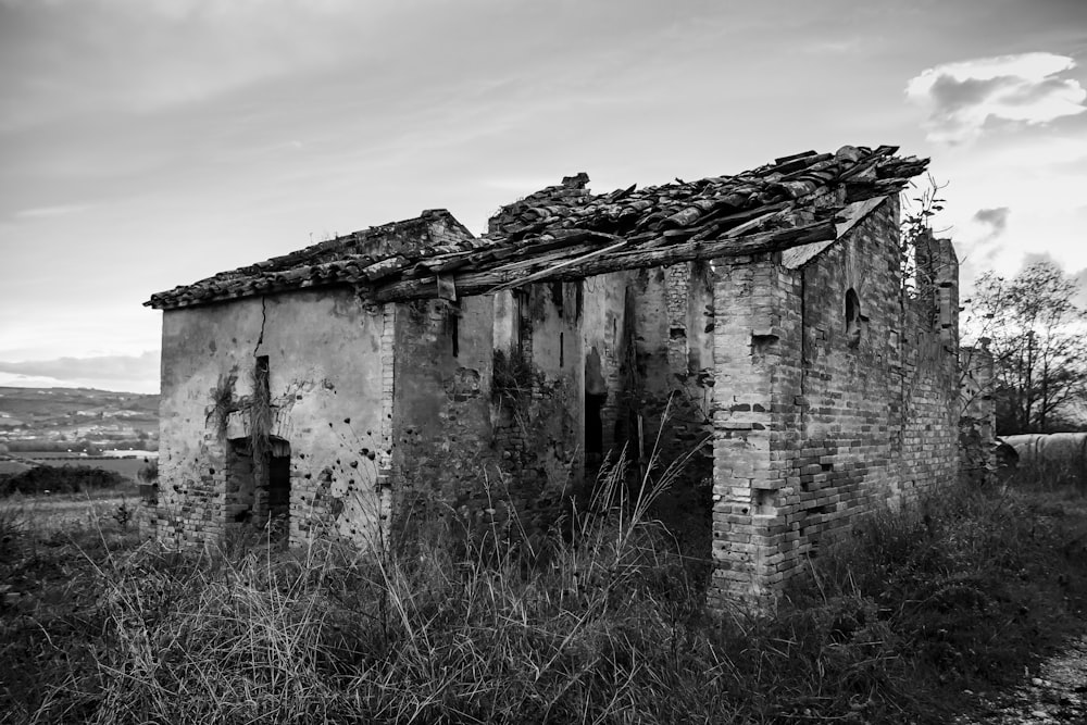 fotografia in scala di grigi di una casa abbandonata