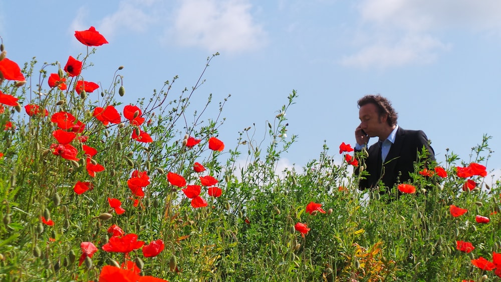 man calling on phone walking in the flower field