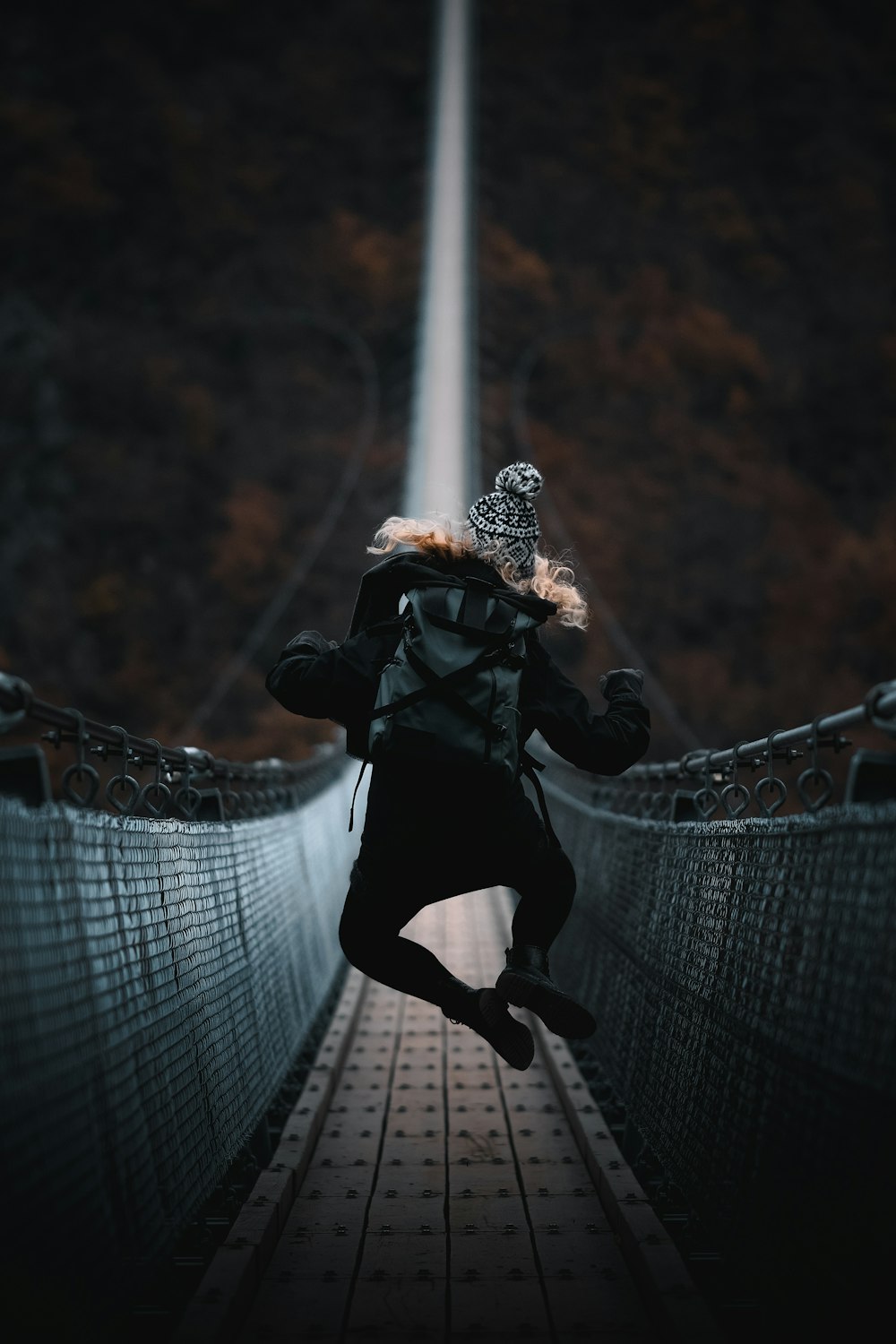 woman jumping on bridge