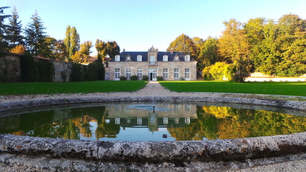 pond in front of building near trees during day