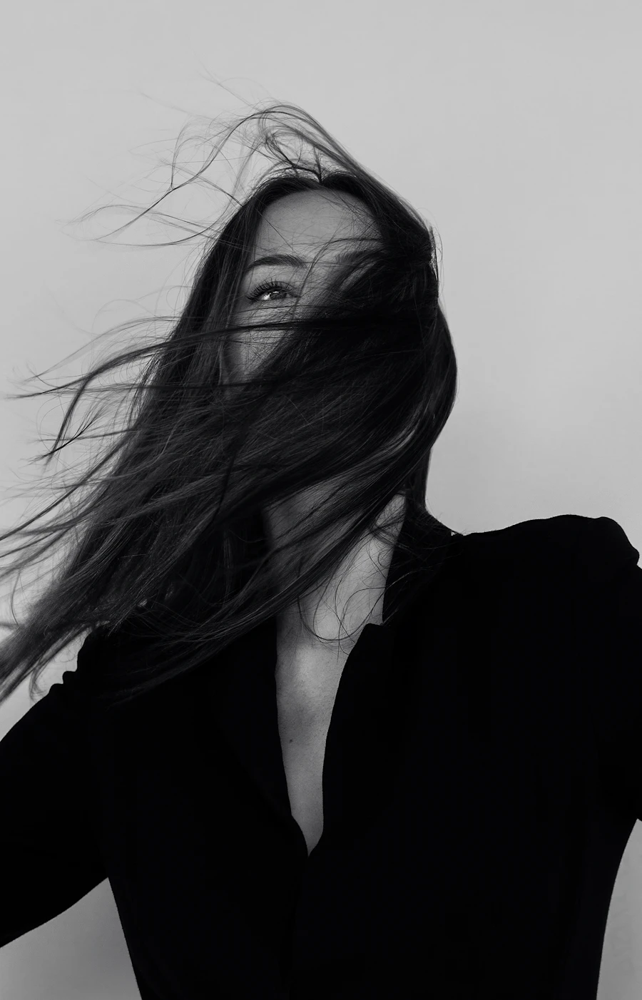 Retrato editorial en blanco y negro con el pelo al viento y blazer oscuro