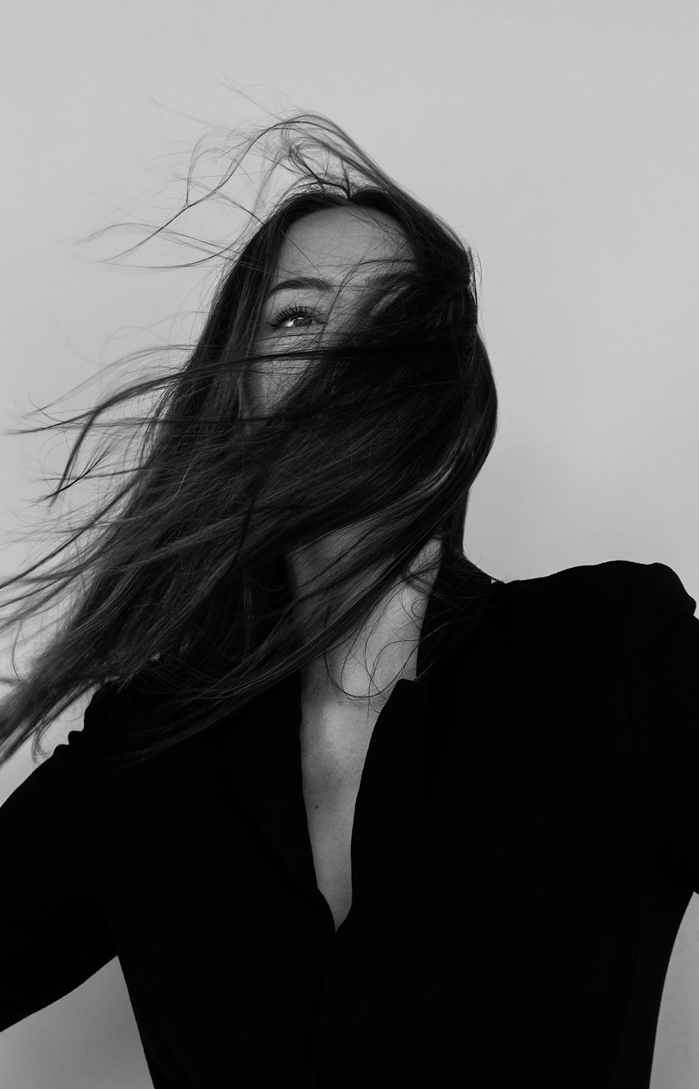 Photographie en niveaux de gris d’une femme portant une chemise à manches longues