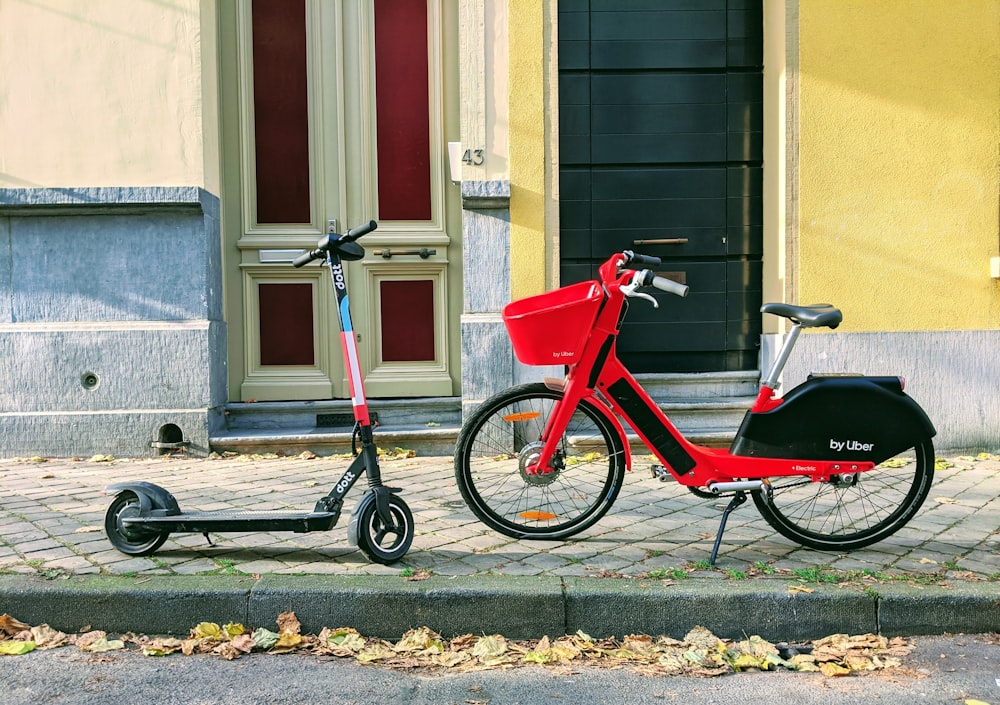 Dos patinetes y bicicletas estacionados al lado de la acera