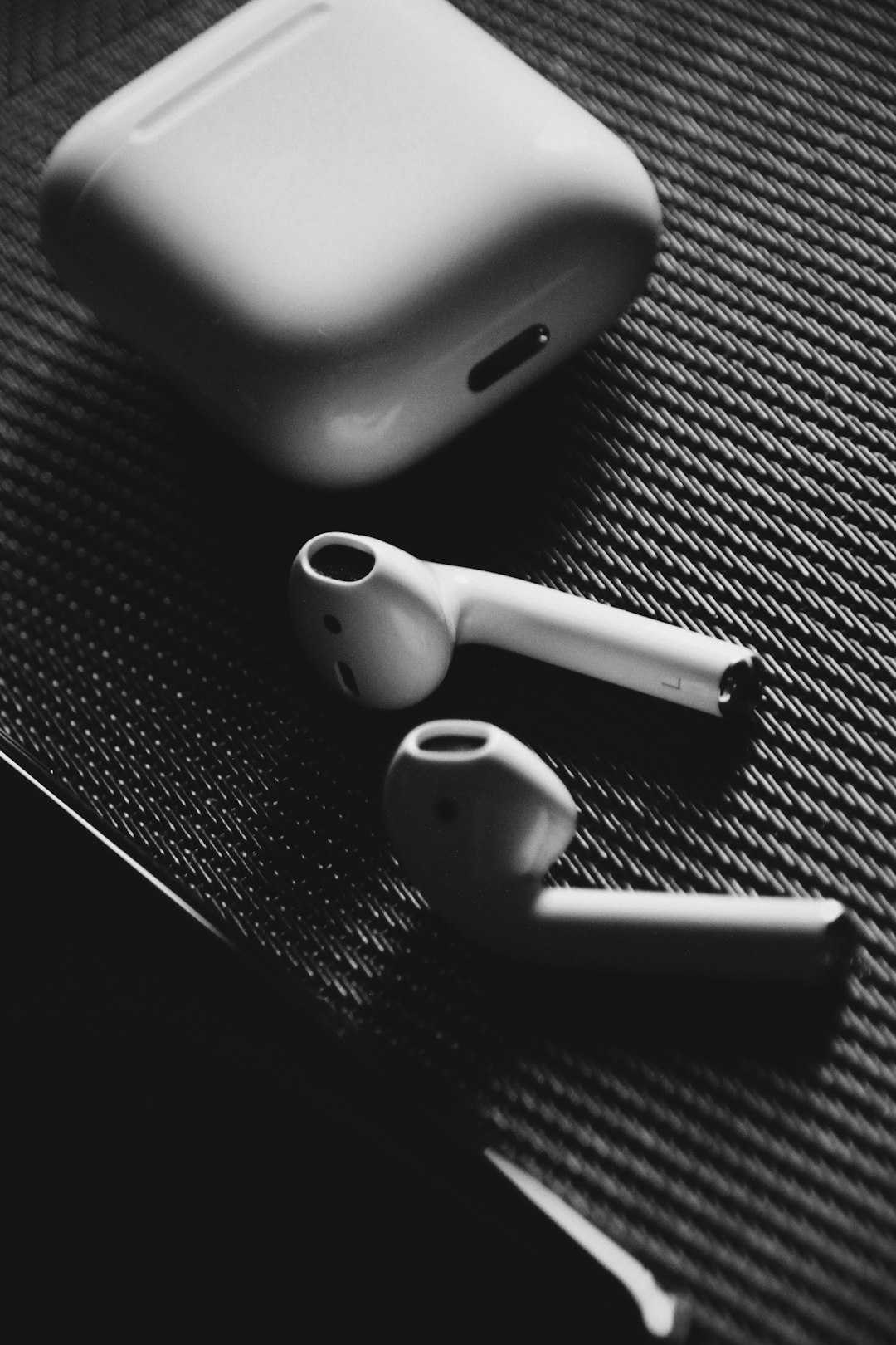 Apple AirPods with charging case on surface