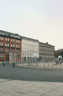 Children playing in the schoolyard surrounded by modern white and gray buildings with soft gradients.