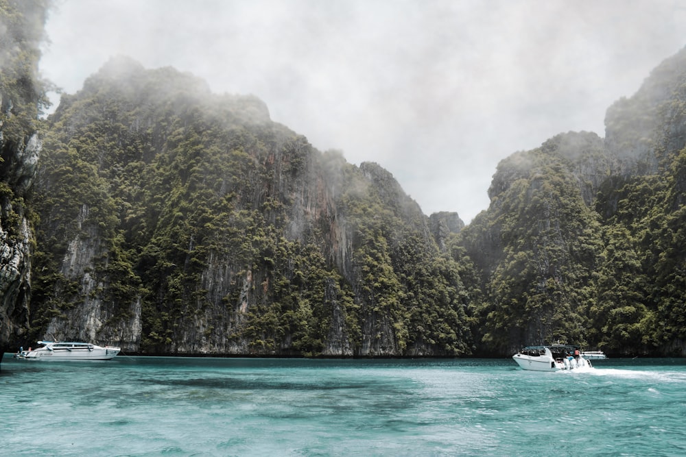 boats on body of water near mountains during day