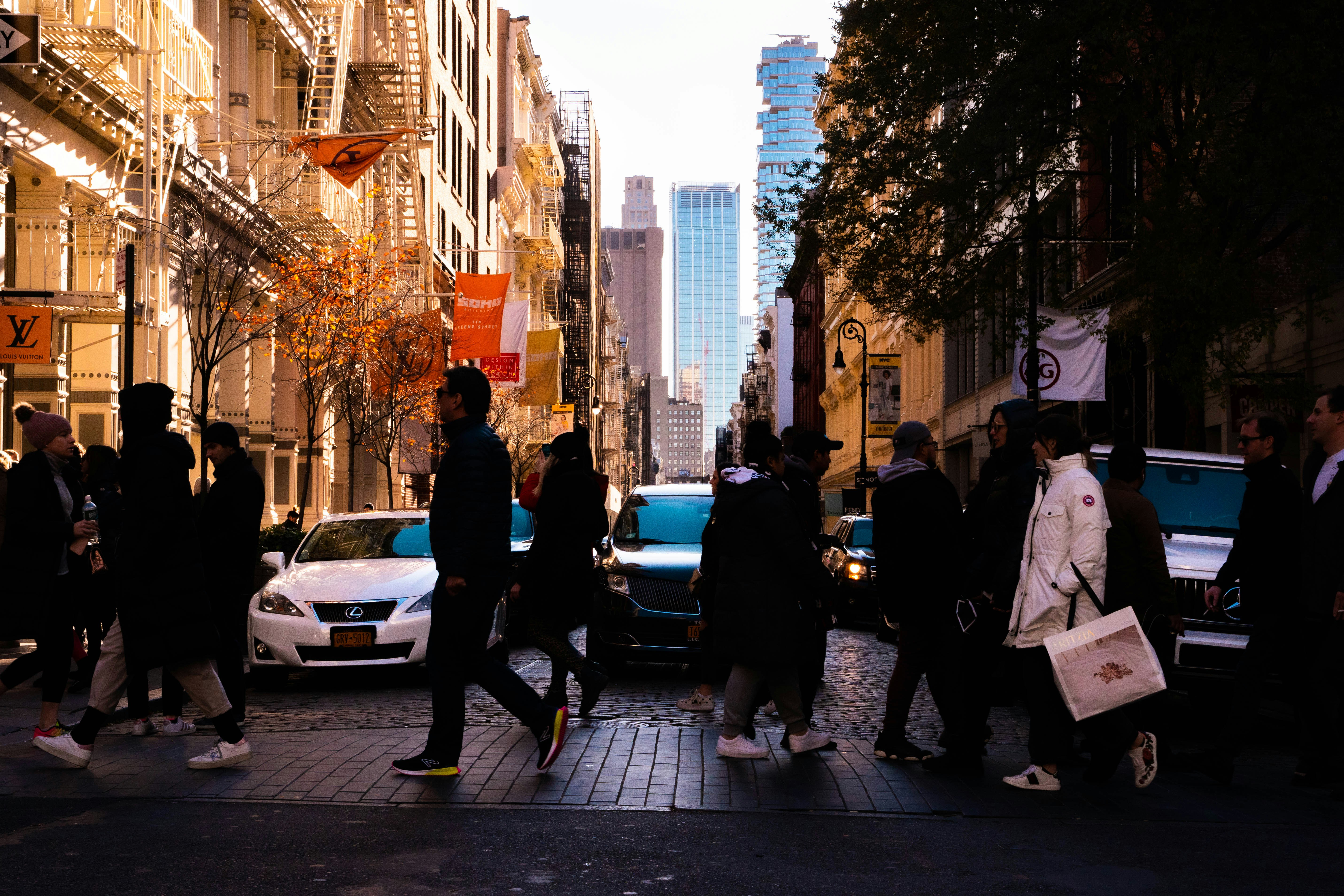 昼間、車で歩道を歩く人々