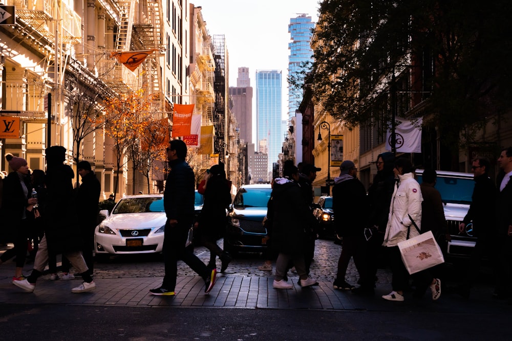 people walking on pavement by cars during daytime