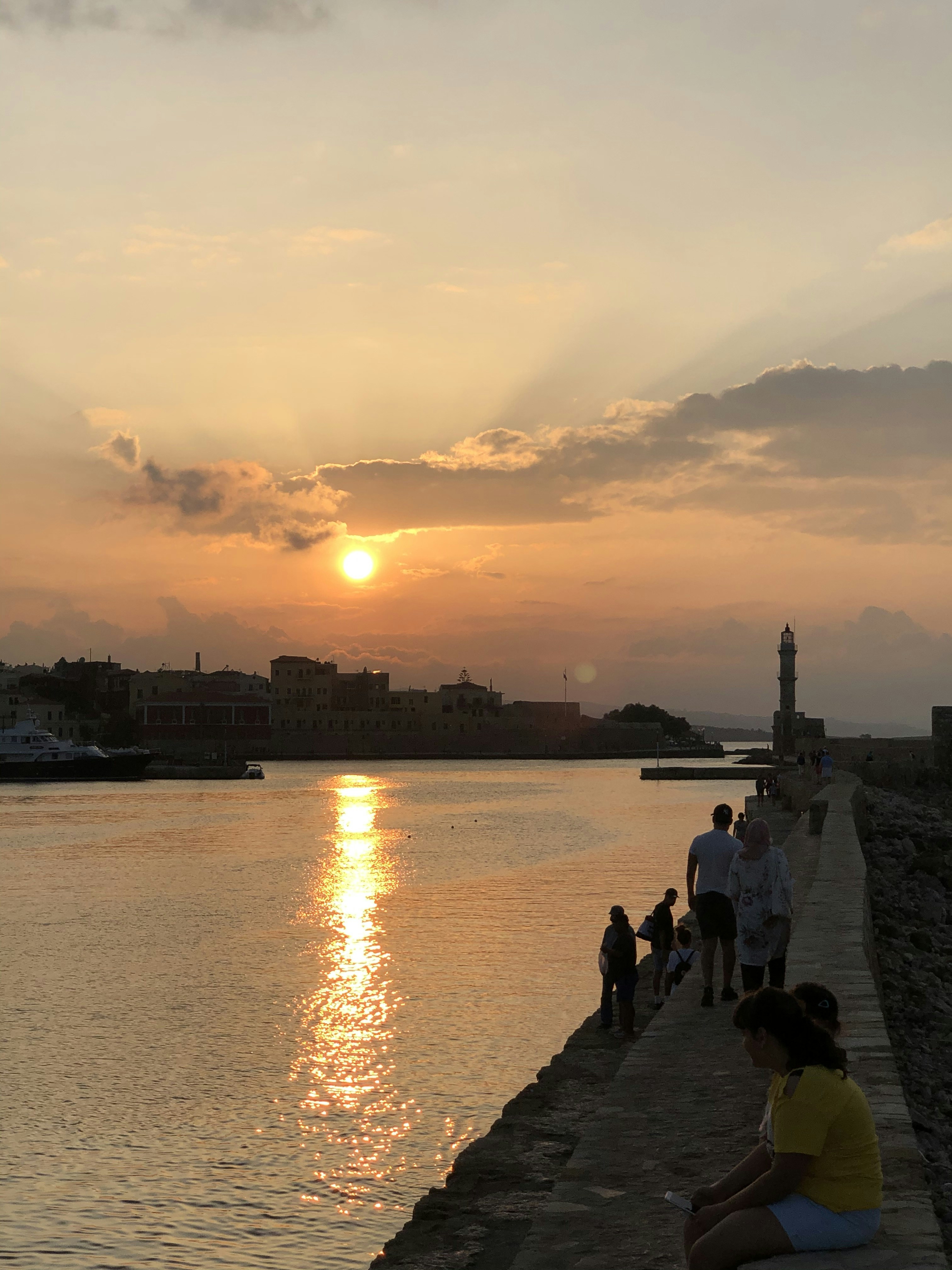 people on shore during golden hour