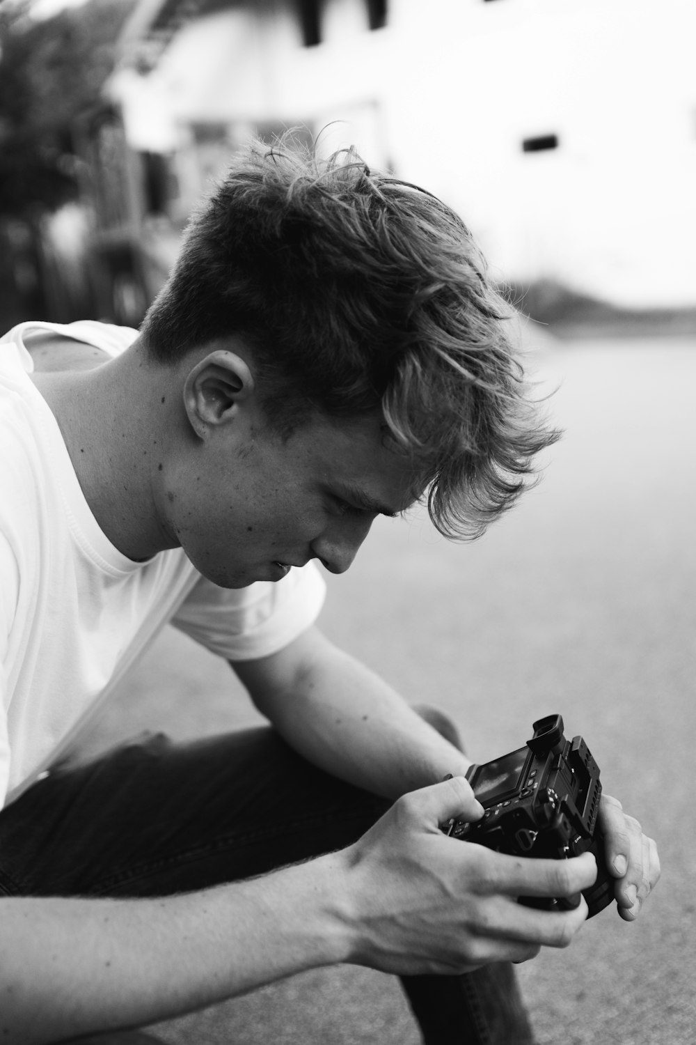 grayscale photo of man using DSLR camera