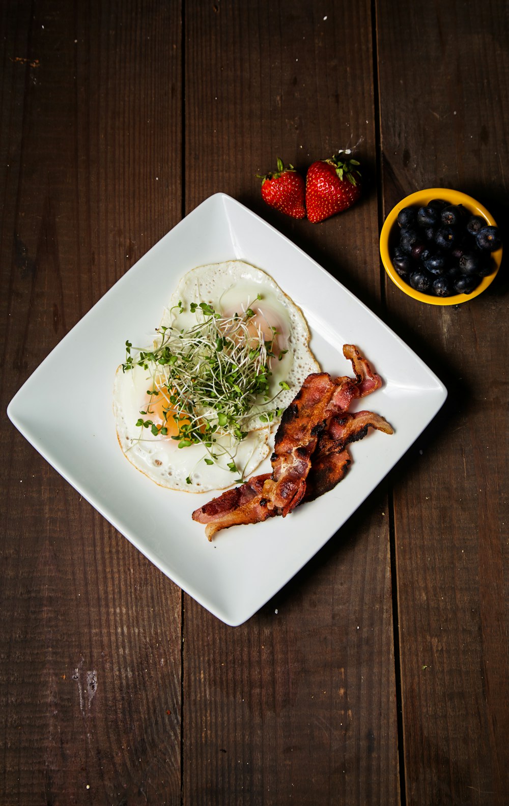 plate of bacon and sunny side up eggs