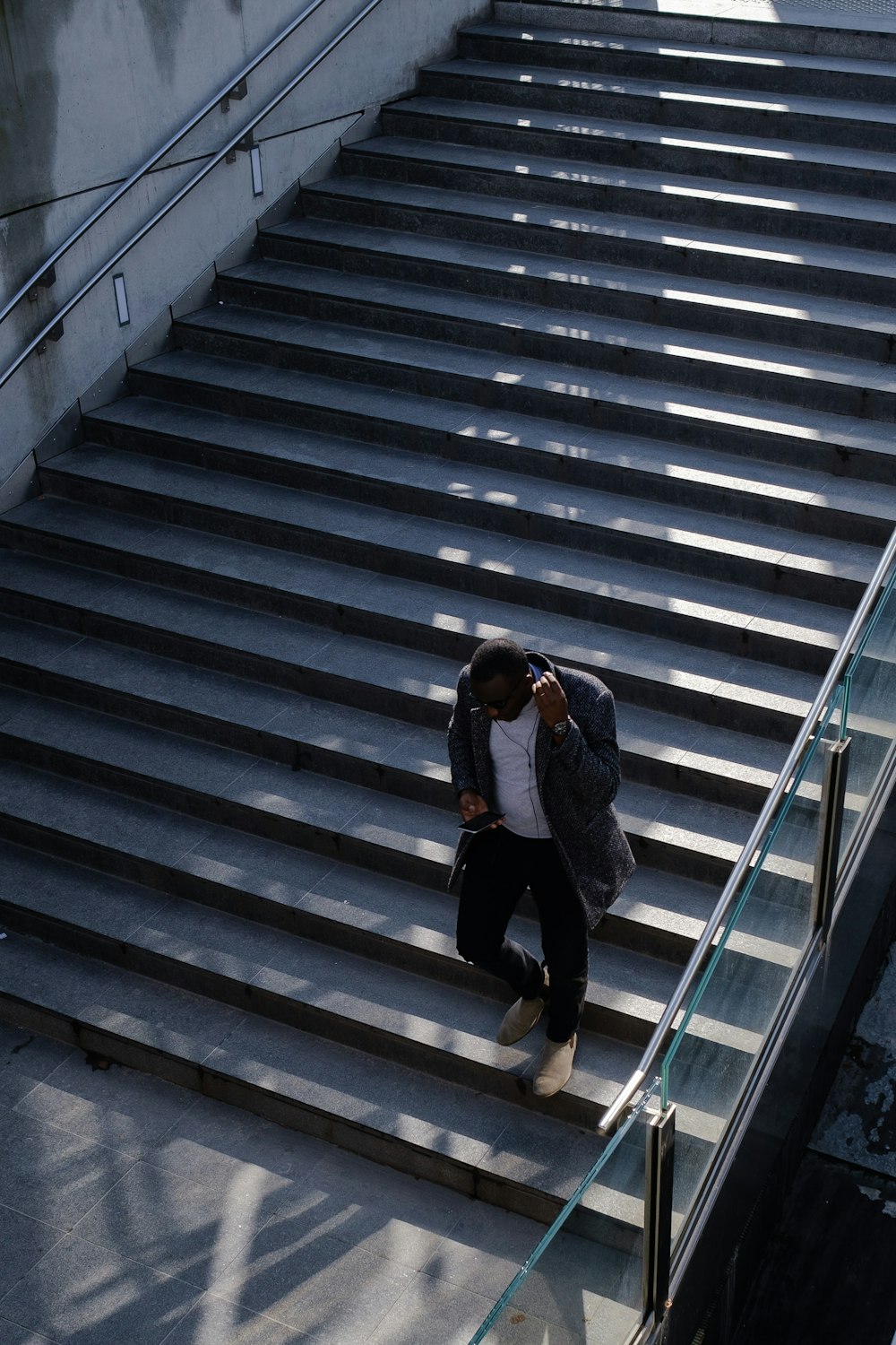 a man walking down a flight of stairs talking on a cell phone
