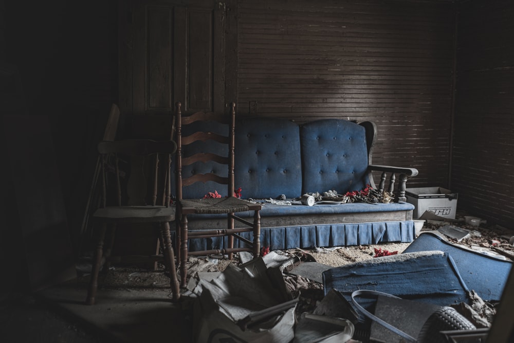 a blue couch sitting in a room next to a chair