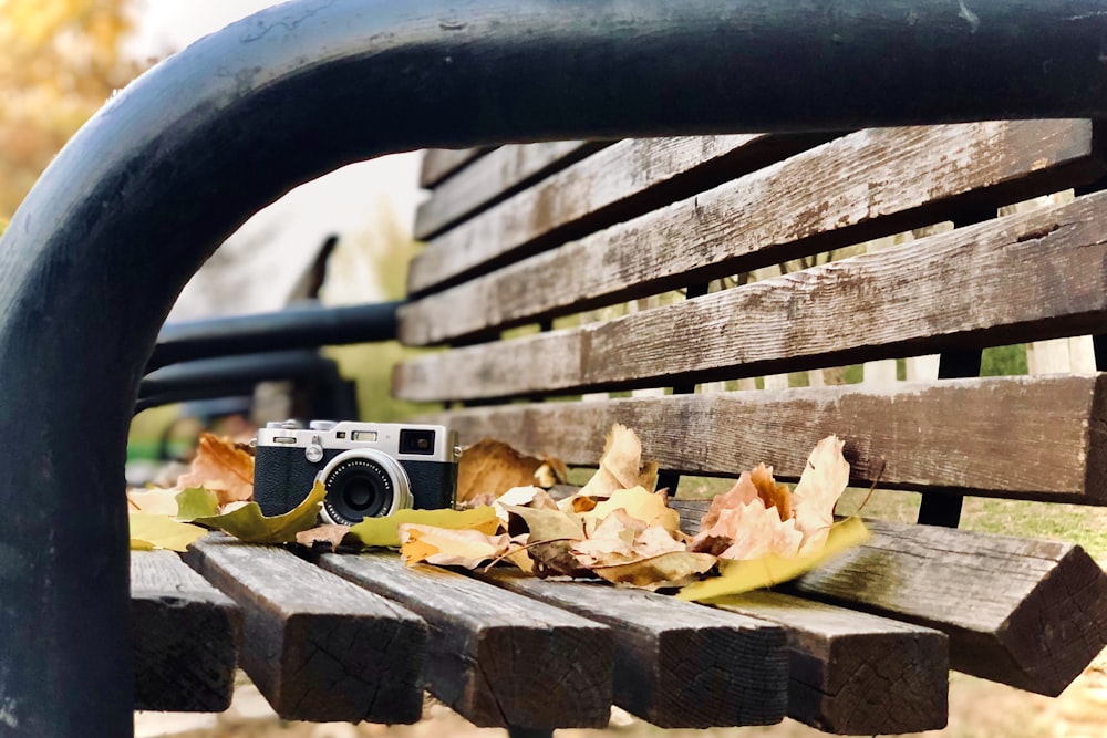 gray and black camera on brown wooden bench during daytime
