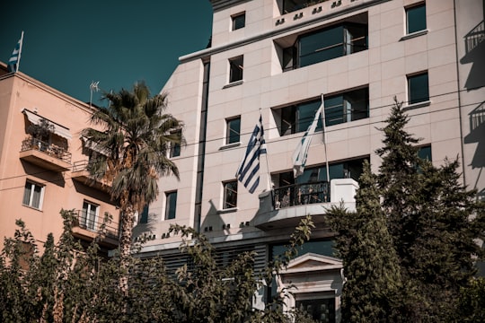white concrete building with flags in Athens Greece