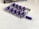 A blister pack containing several purple capsules sits on a white surface. The pack has one capsule missing, which is placed next to it. In the background, there is a box with the label 'Adam's Secret' and a golden badge, partially visible.