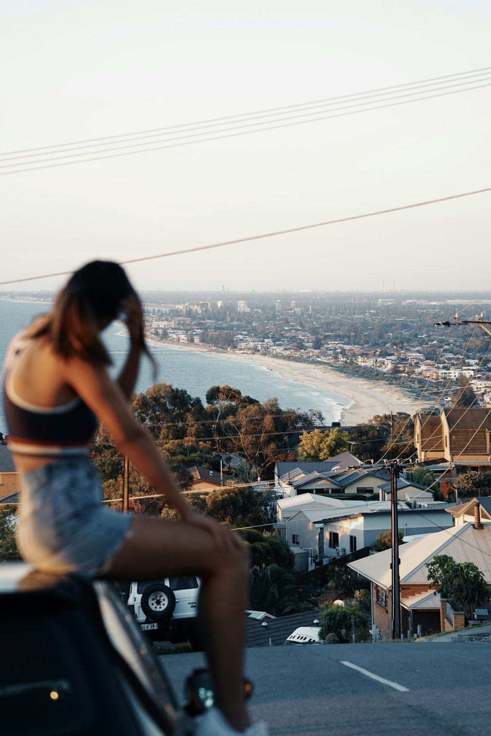 woman in black crop-top sitting on car