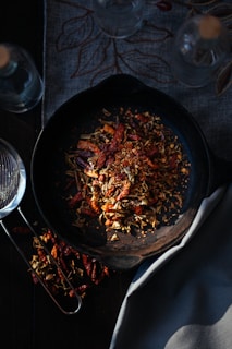 A beautifully seasoned cast iron skillet resting on a rustic wooden countertop with fresh herbs nearby.