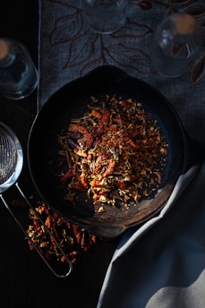 A beautifully seasoned cast iron skillet resting on a rustic wooden countertop with fresh herbs nearby.