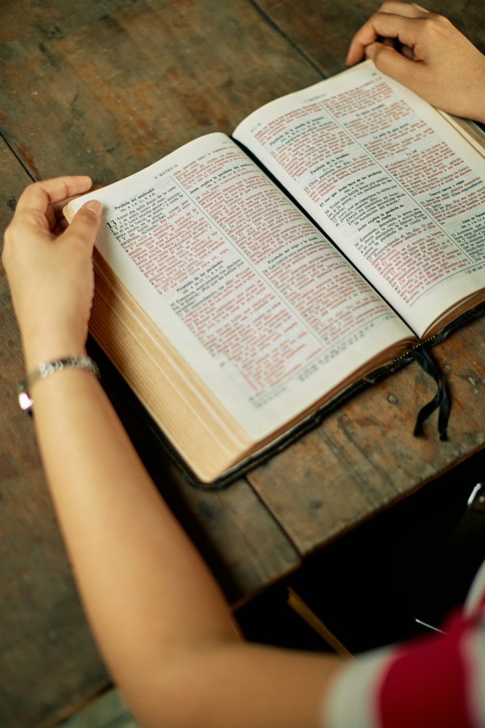 an open bible on top of wooden table