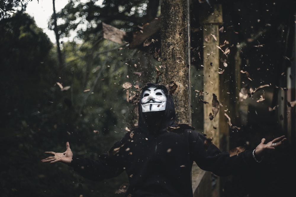 man in black jacket and Guy Fawkes mask