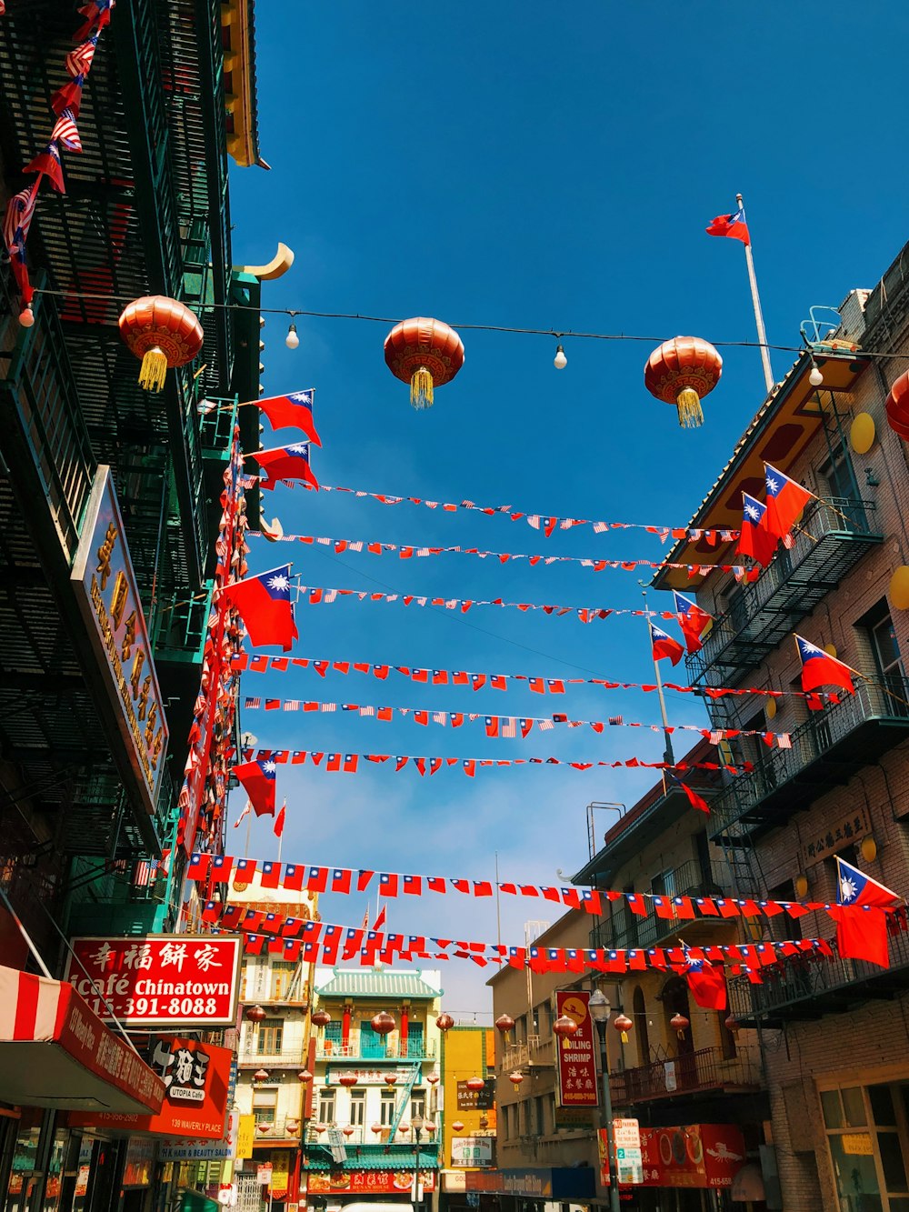 decoração chinesa vermelha pendurada entre edifícios durante o dia