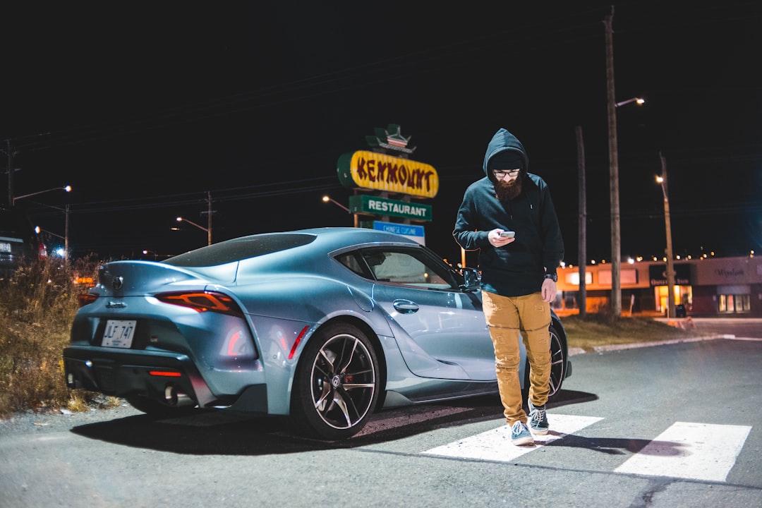 man walking near gray coupe