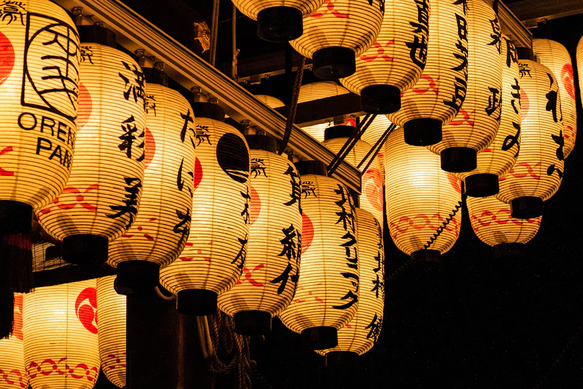 Warm lanterns lighting a narrow street in Japan at night