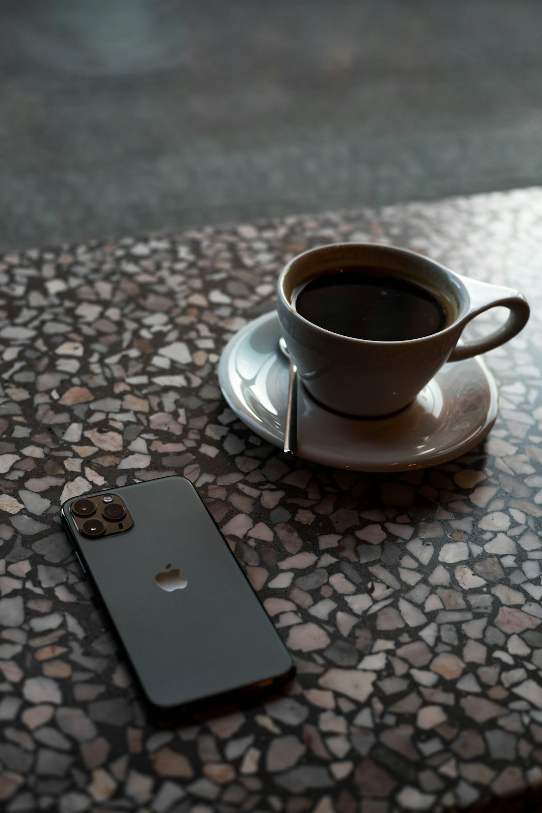 white ceramic coffee mug beside black iPhone 11 Pro