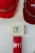 A set of red hard hats is mounted on a wall above an emergency alarm system. The alarm consists of a button to break glass in case of emergency and a red panel beneath it.