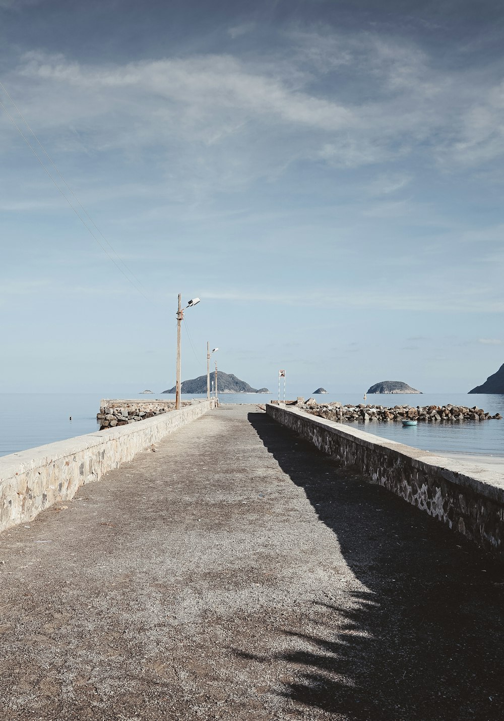 a long stone wall next to a body of water