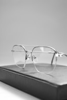 Minimalist round gold metal glasses balanced on an open book page, hinting at timeless elegance.