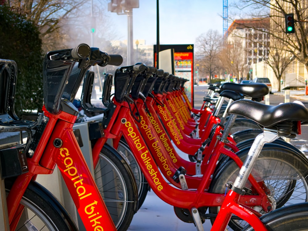 a row of red bicycles parked next to each other