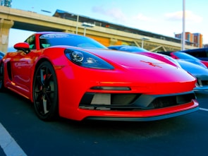 A vibrant red sports car showcased with a city skyline in the background.