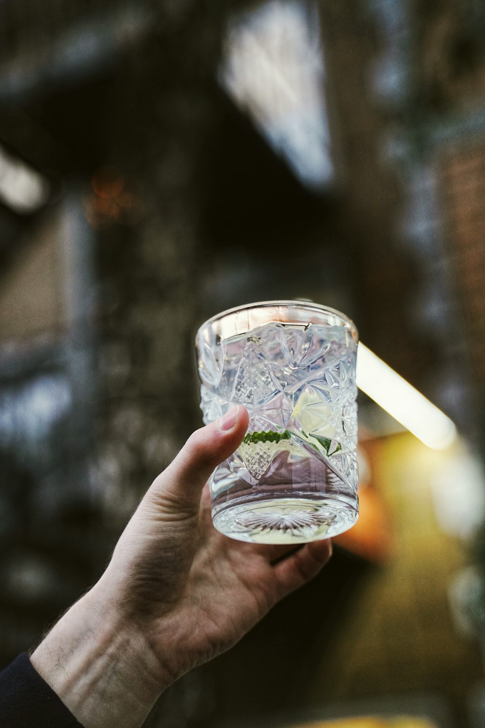 person wearing clear drinking glass