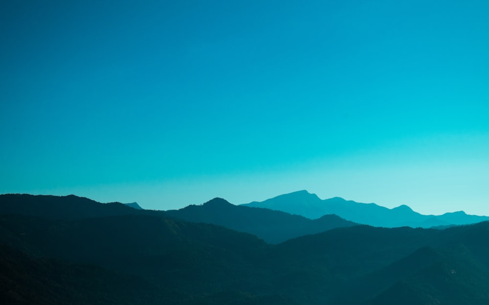 silueta de montañas bajo cielo azul