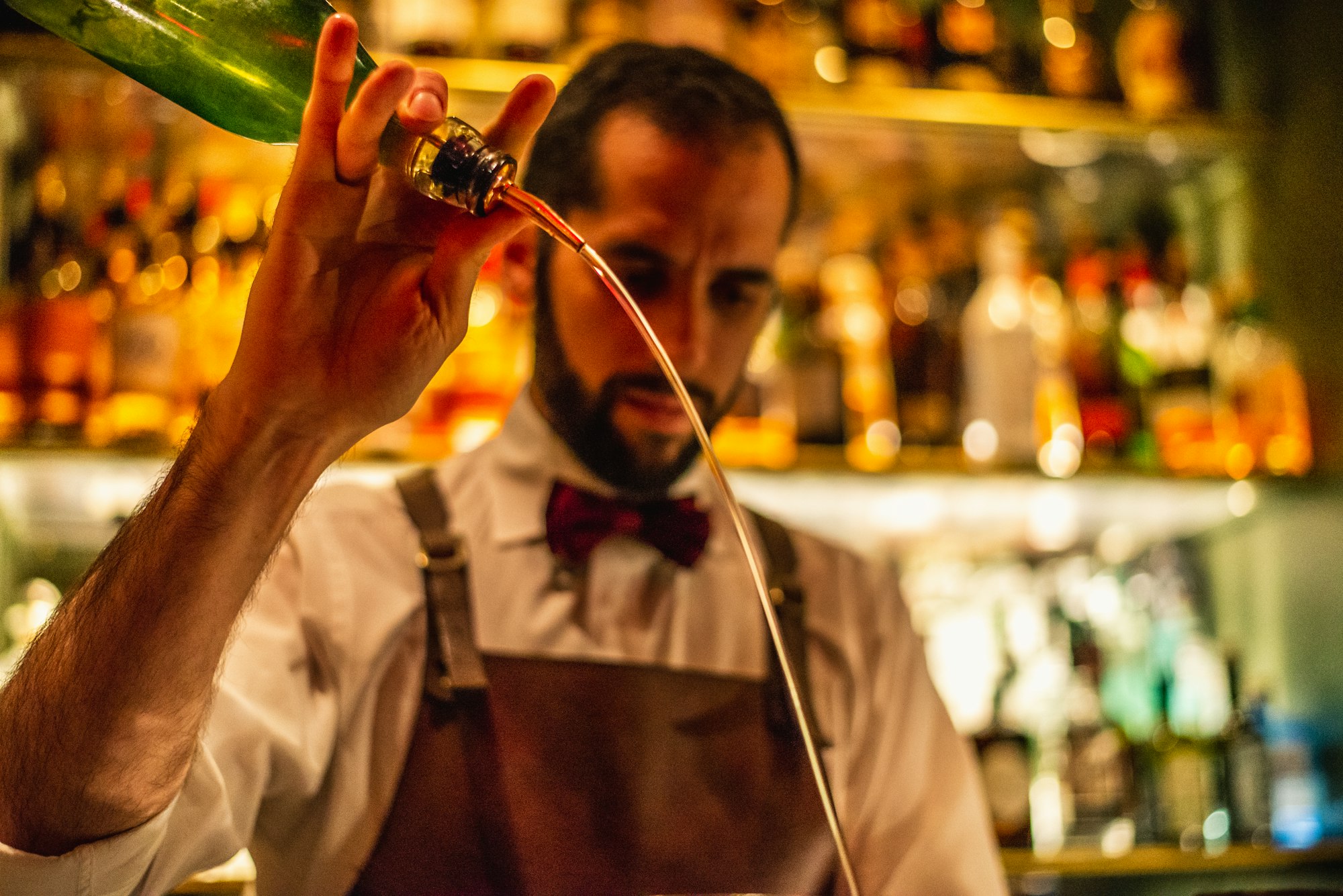 Bartender in a bar restaurant pouring a crafting a Christmas cocktail with tequila and lemon.