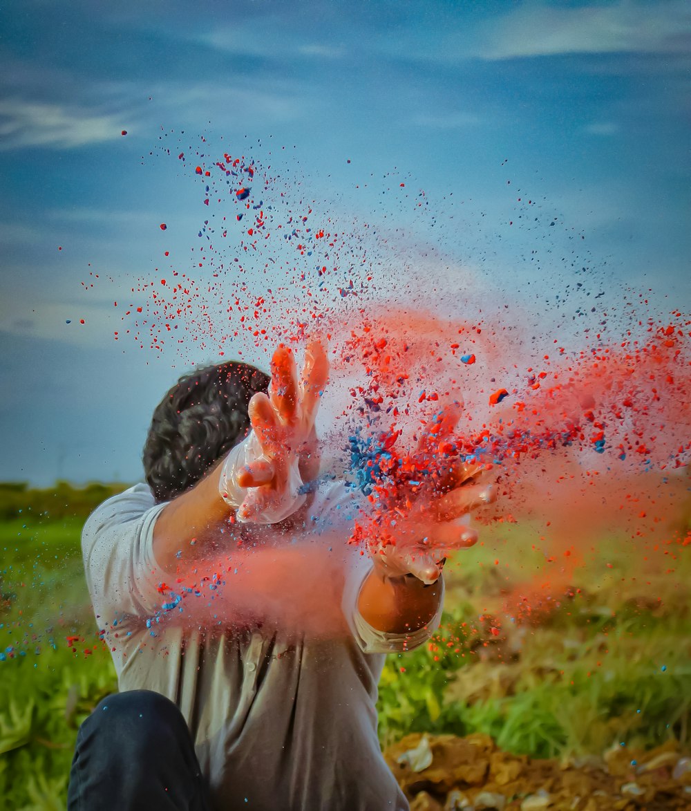 a man is throwing colored powder in the air