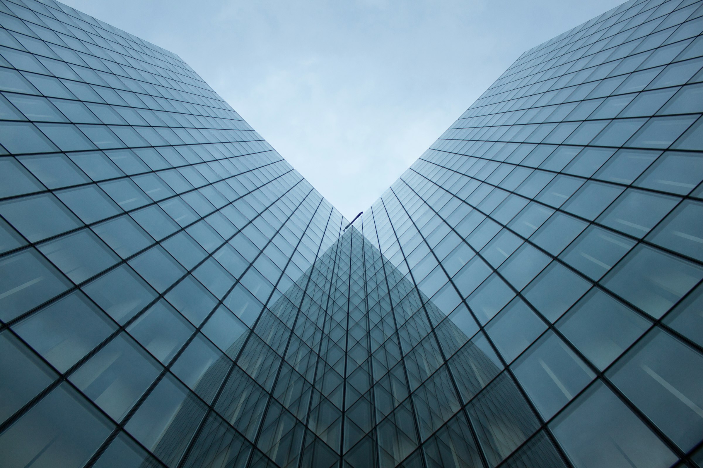 Looking up between two modern glass office buildings