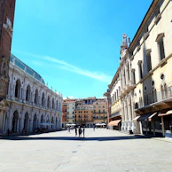 Early morning shot of a peaceful plaza in Barão de Cocais with soft sunlight and few people walking.