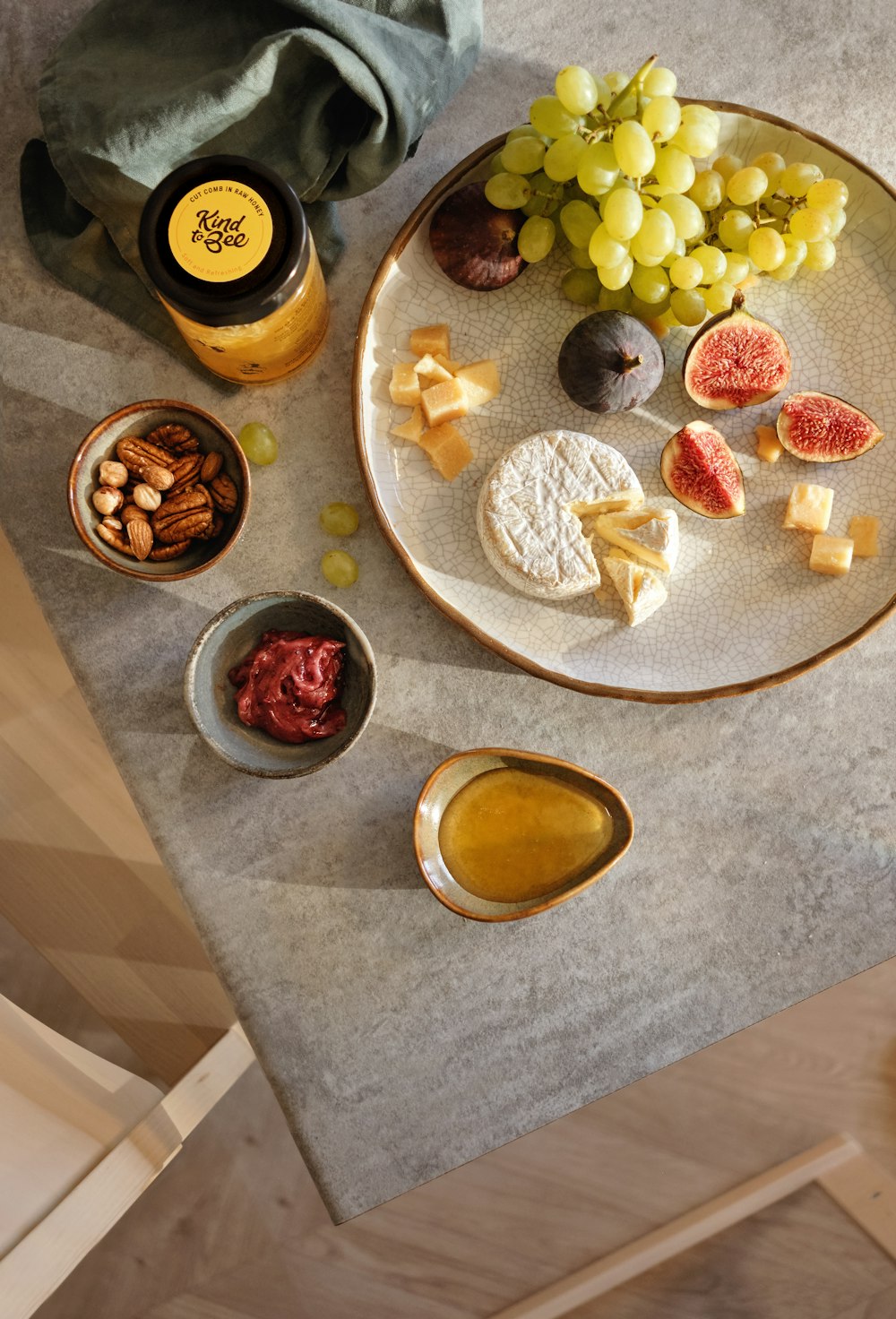 green grapes near, sliced fig, and mangosteen fruit on plate near walnut and olive oil