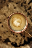 A bowl of creamy cow ghee with a wooden spoon.
