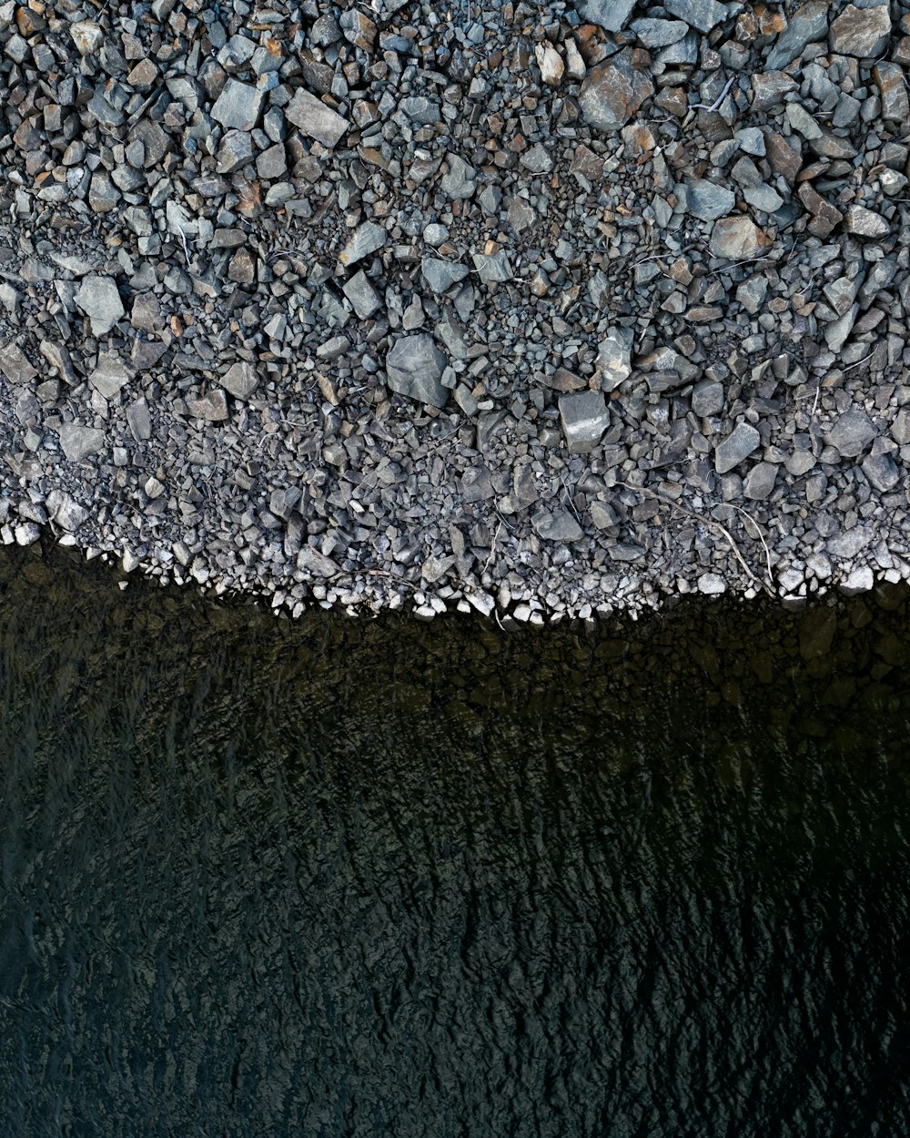 grey rocks beside body of water