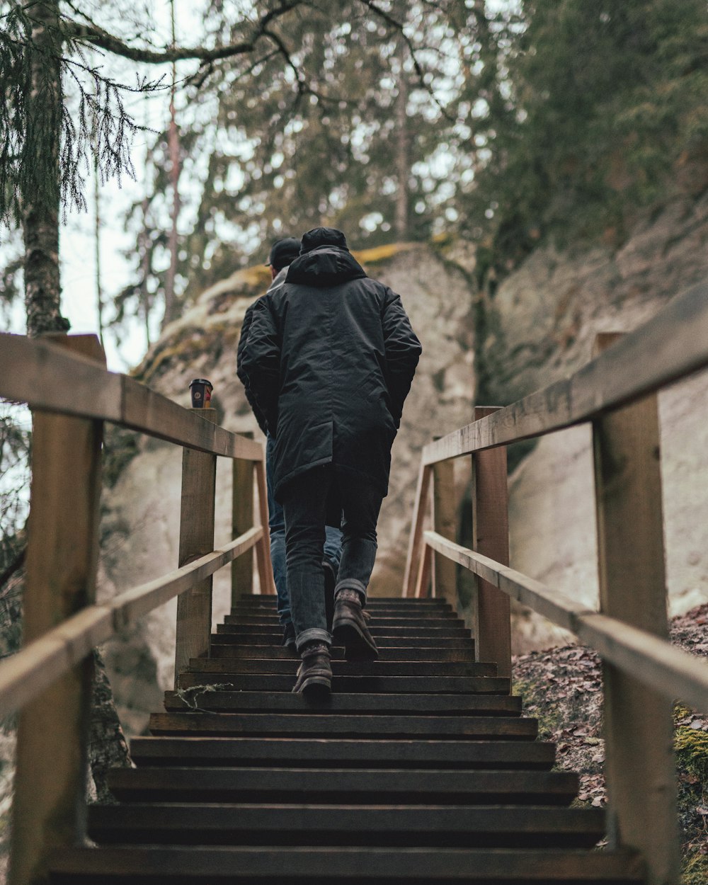 person walking on brown wooden staircase during daytime