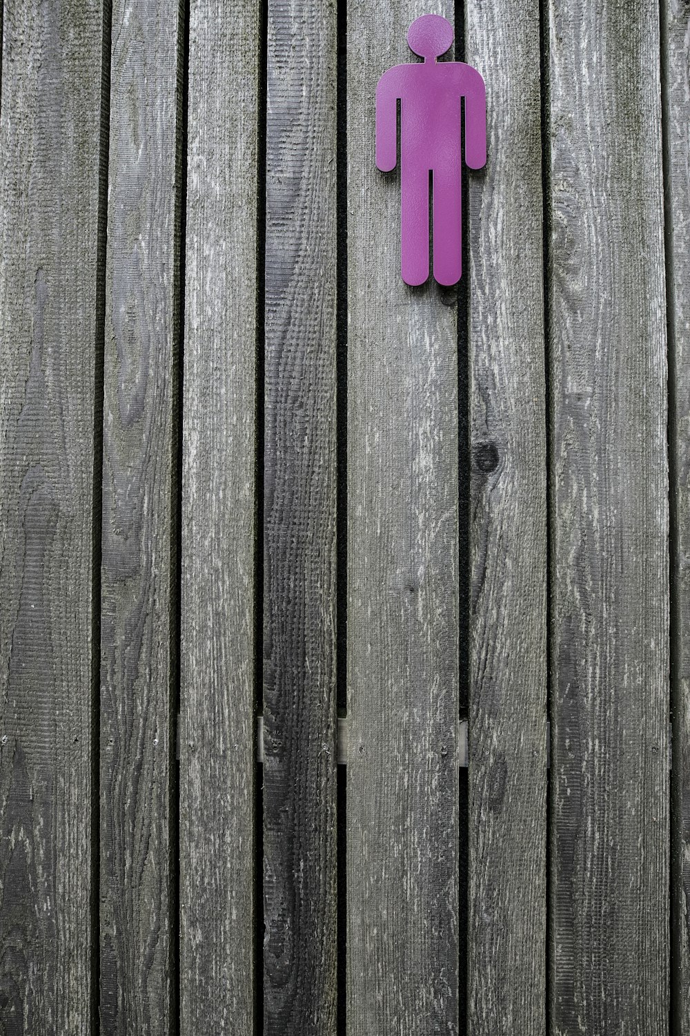 pink human sign on wooden surface