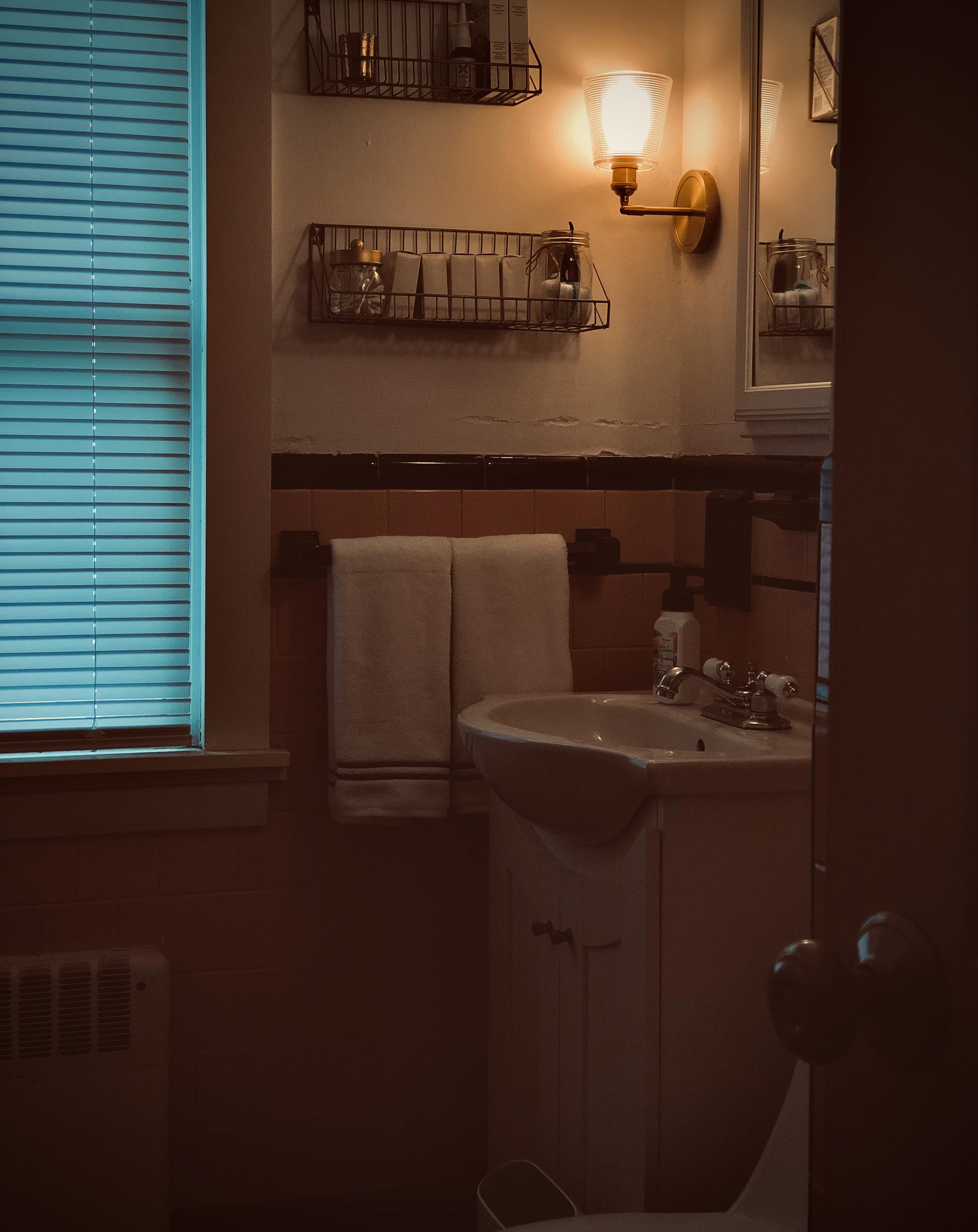 Before: dated bathroom with a beige vanity and tiled walls
