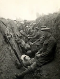 a group of men sitting next to each other in a trench