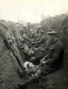 a group of men sitting next to each other in a trench